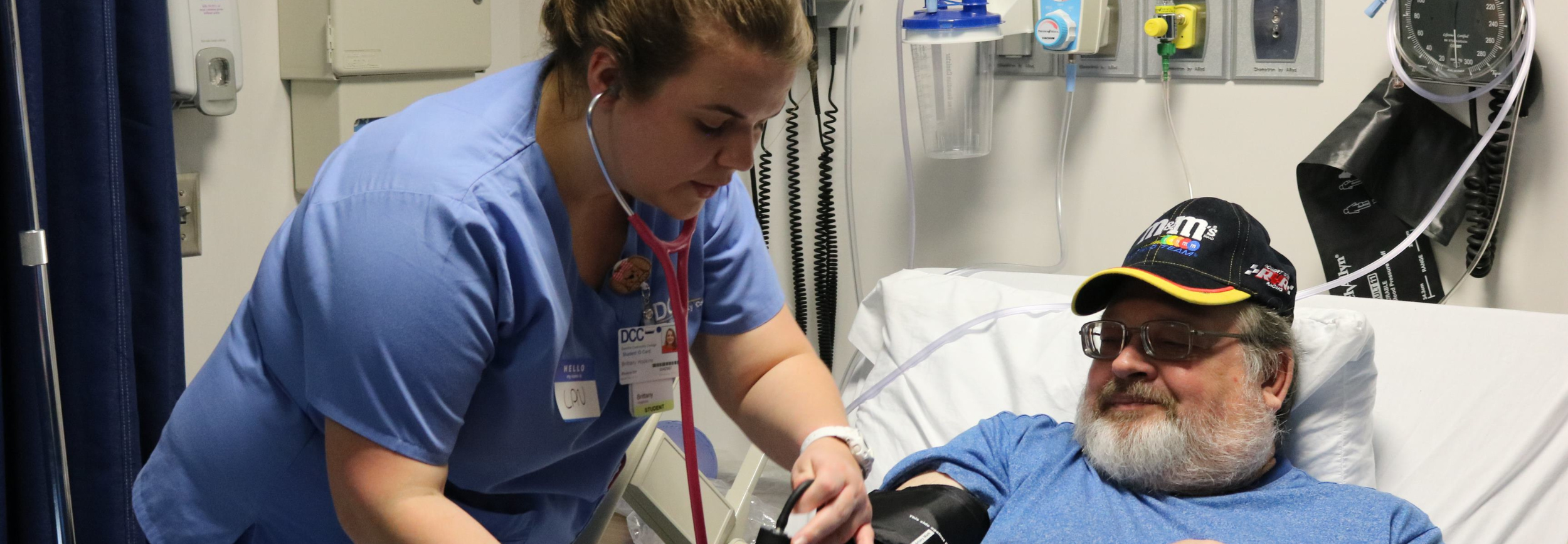 Nursing student taking blood pressure on volunteer.